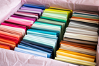 Assorted fat quarter fabric bundle with folded pastel and bold colors in trays