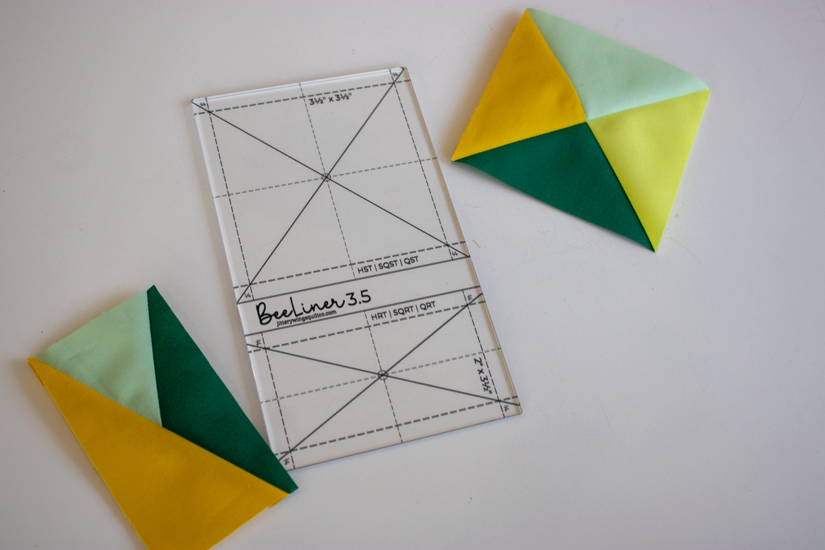 Clear quilt trimming ruler with diagonal and block layout guide lines, marked grid.