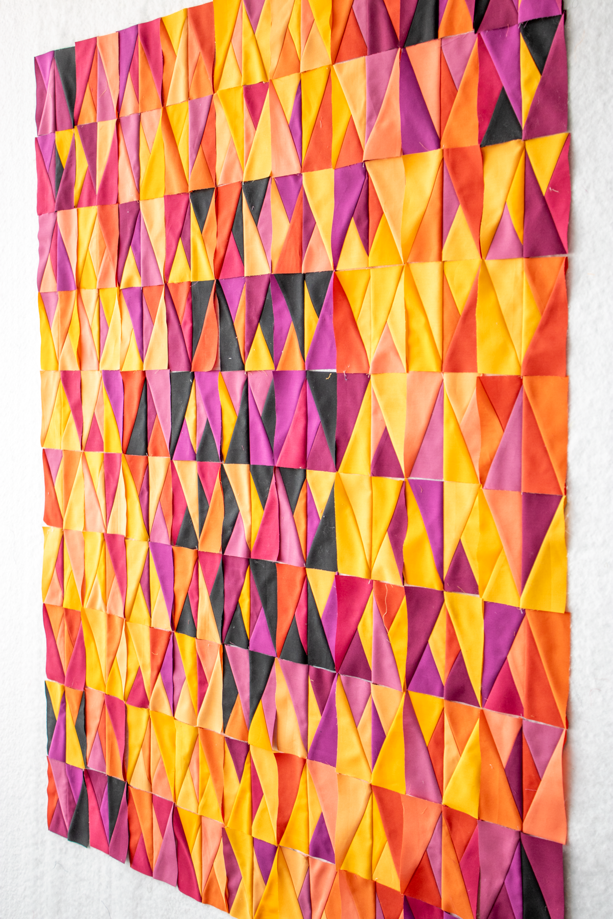 Multicolor geometric triangle quilt close-up with bright patchwork triangles